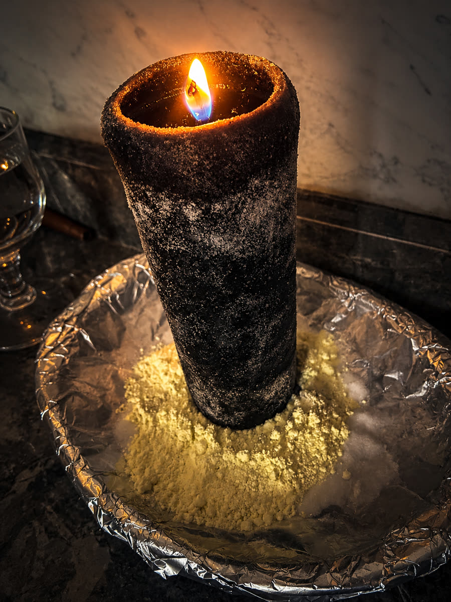 Vela ritual encendida sobre sal y azufre